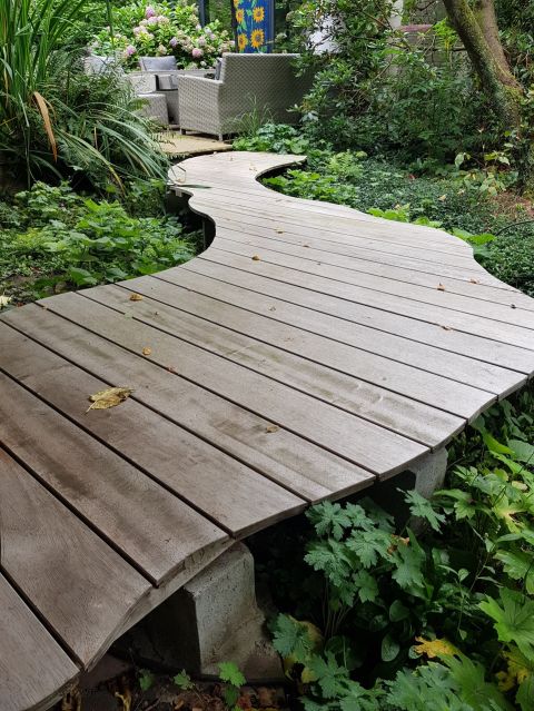 Houten Kronkelpad op muurtjes tussen de aanplanting